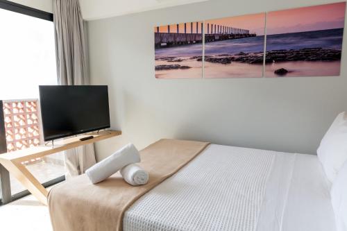 a bedroom with a bed with a flat screen tv at Hotelito del Mar Playa del Carmen in Playa del Carmen