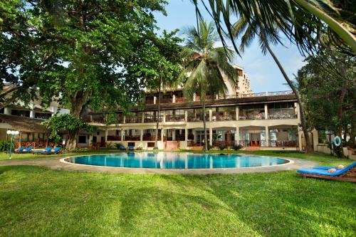 um resort com uma piscina em frente a um edifício em Neptune Beach Resort - All Inclusive em Bamburi