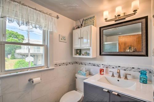 un bagno con un water, un lavandino e una finestra di Deck and Beach Access Waterfront Cape Cod Cottage a Wareham