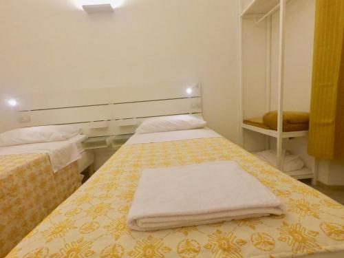 a bedroom with two beds with towels on them at Central Savona in Savona