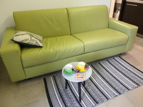 a living room with a green couch and a table at Apartma Kurji vrh - Chicken top in Kranjska Gora