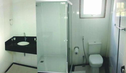 a bathroom with a shower and a toilet and a sink at Atrius Hotel in Rio Bonito