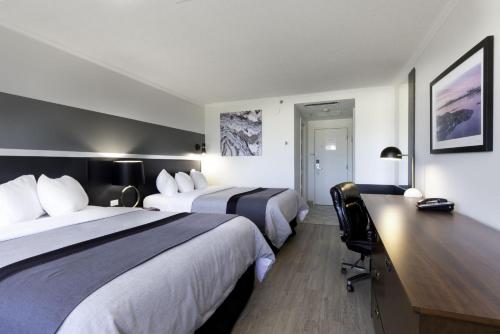リムースキにあるHotel Rimouskiのベッド2台と机があるホテルの部屋