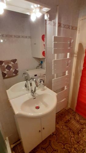 une salle de bain blanche avec un lavabo et un miroir dans l'établissement GRAND CAP Appartement 2 chambres vue mer, à Saint-Jean-de-Monts