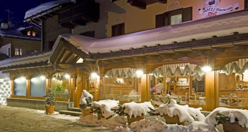 a restaurant covered in snow in front of a building at Albergo Alpenrose in Livigno