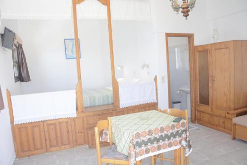 a room with a bed and a table and a mirror at Blue Sea Studios in Arkasa