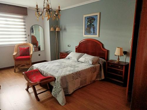 1 dormitorio con cama, silla y espejo en O Seixo 1, en Mugardos