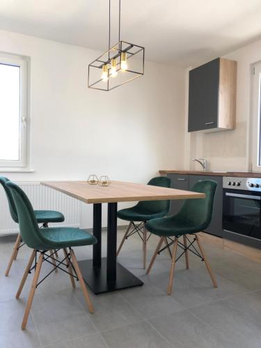 eine Küche mit einem Holztisch und grünen Stühlen in der Unterkunft business & fitter Apartment in Nürnberg