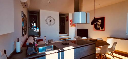 une cuisine avec un évier et un salon dans l'établissement Magnifique Duplex vue Mer, à Menton