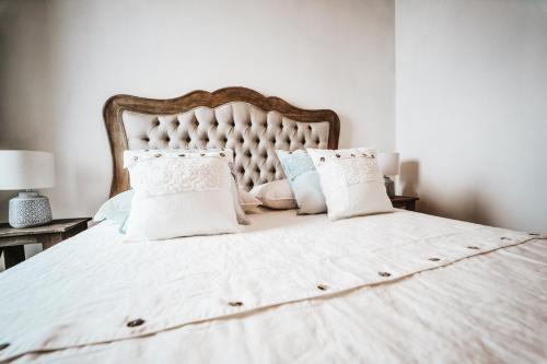 - un lit avec des draps et des oreillers blancs dans l'établissement Trullo Malvasia-Trulli Antì Charme & Relax, à Alberobello