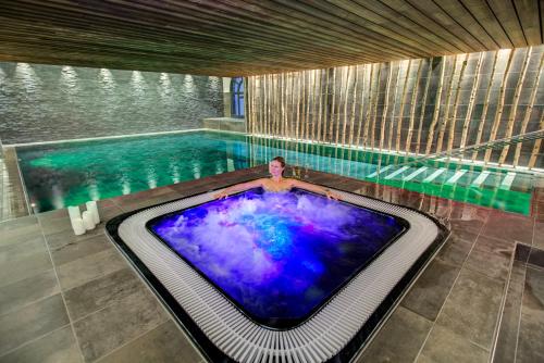 une personne debout dans une piscine avec une grande piscine dans l'établissement Résidence Luxe 5*,Spa & Fitness, La Cordée Appartement 214, à Chamonix-Mont-Blanc