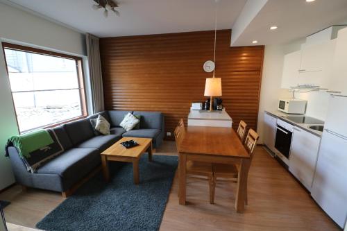 uma sala de estar com um sofá, uma mesa e uma cozinha em Apartment Ylläs Ski Chalets 8106, 2 Hissilippua talvella em Ylläsjärvi