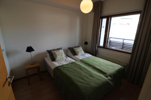 um quarto com uma cama verde e uma janela em Apartment Ylläs Ski Chalets 8106, 2 Hissilippua talvella em Ylläsjärvi