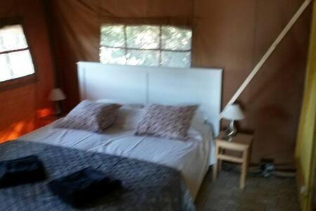 a bedroom with a large white bed and a window at Acacia in Mazan