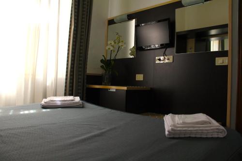 a bedroom with a bed with a tv on the wall at Hotel Il Castello in Assisi