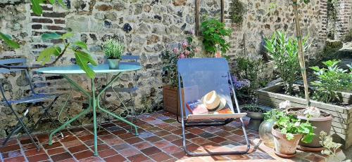 une table et une chaise dans un jardin avec des plantes dans l'établissement -La Maison Balancoire -Parking privé -Coeur historique -La Clef de Honfleur, à Honfleur
