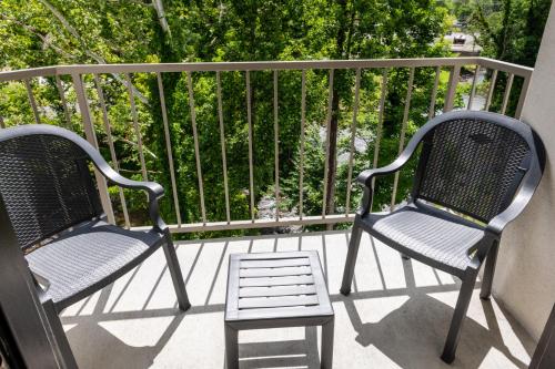 two chairs and a stool on a balcony at Twin Mountain Inn & Suites in Pigeon Forge