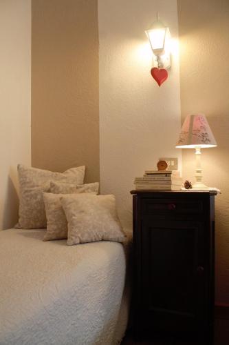 a bedroom with a bed and a lamp on a night stand at Le Coeur du Pont in Donnas