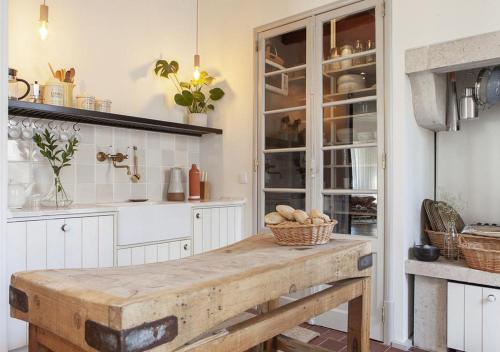 cocina con armarios blancos y mesa de madera en Bohemian Luxury - Intendente, en Lisboa