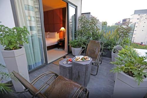 un balcón con sillas y un plato de comida. en Hippodrome Hotel Condesa, en Ciudad de México