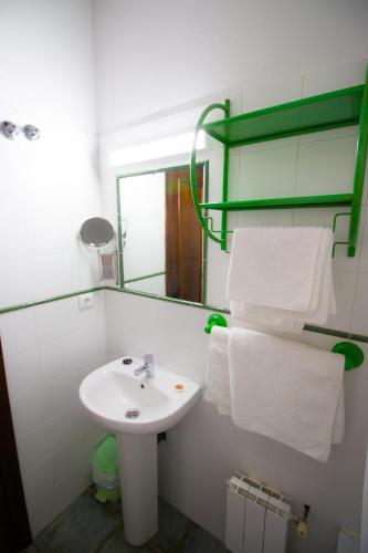 a bathroom with a sink and a mirror and towels at Pasaje San Jorge in Comillas