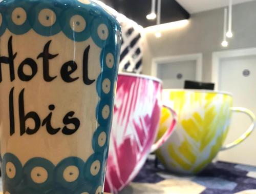 three coffee cups sitting on a table at ibis styles Bolesławiec in Bolesławiec