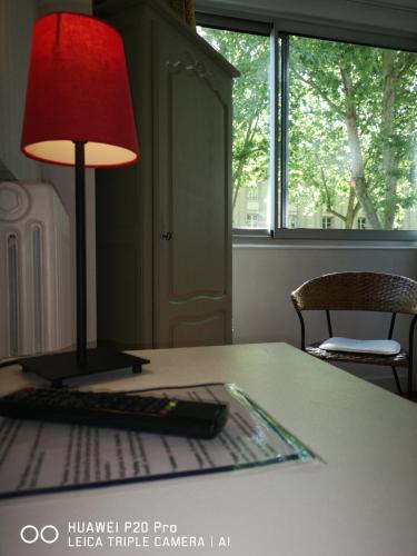 a red lamp sitting on a table with a keyboard at Hôtel Trianon Tours in Tours