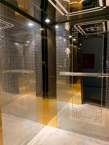 a room with a glass wall with a table at Buyutat Najran Serviced Apartments بيوتات نجران للشقق المخدومة in Najran