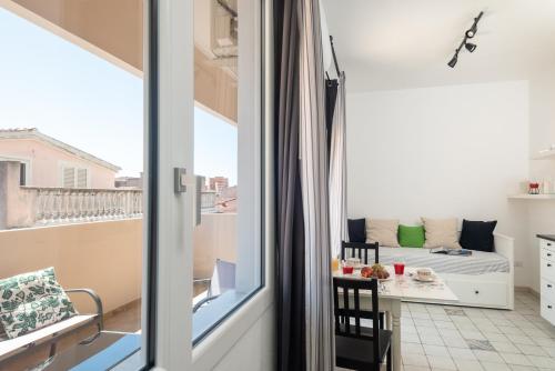 a room with a balcony with a bed and a table at Altré Guest House in Olbia