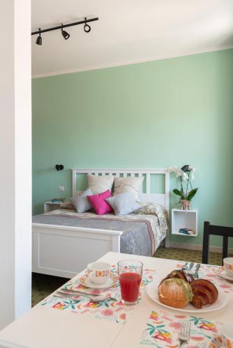 a bedroom with a bed and a table with a plate of food at Altré Guest House in Olbia