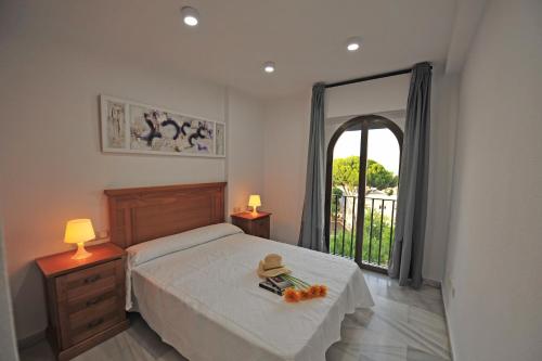 - une chambre avec un lit, une table et une fenêtre dans l'établissement Playa Santa María 3 Dormitorios 2 Baños, à Cadix