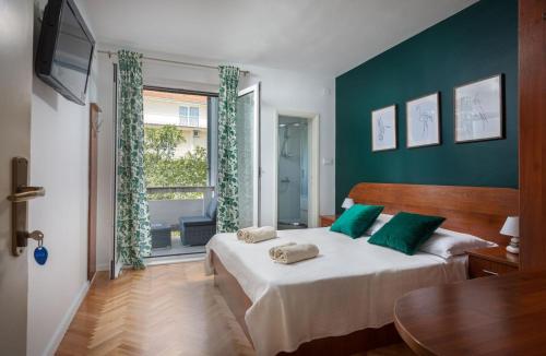 Apartments Agneza Tucepi في توسيبي: غرفة نوم بسرير مع جدران خضراء وطاولة