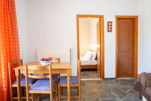 a dining room with a table and chairs and a bedroom at Giapis apartment in Mikros Gialos