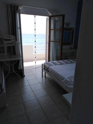 a bedroom with a bed and a view of the ocean at Marilena in Skala Eresou