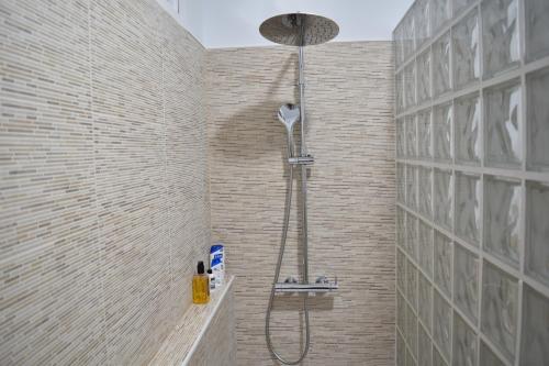 y baño con ducha en una pared de ladrillo. en Apartamento La Discusión de Veedor 12, en Cádiz