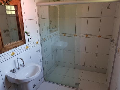 a bathroom with a glass shower and a sink at Pousada Beira rio in Visconde De Maua