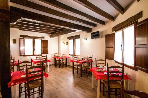 een eetkamer met rode tafels en stoelen bij Pasaje San Jorge in Comillas