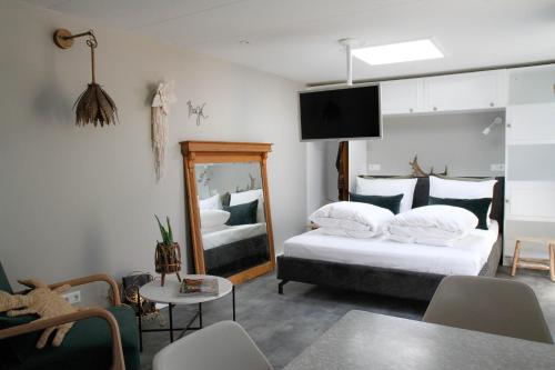 Una habitación de hotel con dos camas y un espejo. en Fabel aan Zee, en Zandvoort