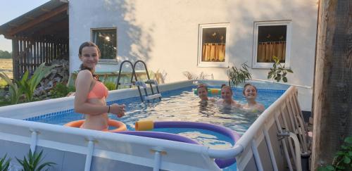 a woman and three children playing in a pool at Chrom Ranch Reiterhof in Memmingen