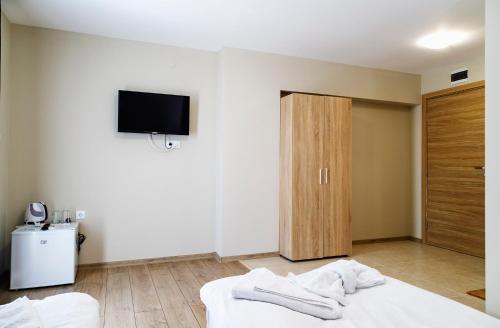 a bedroom with a bed and a tv on the wall at family hotel - City hotel yambol in Yambol