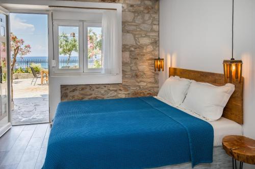 a bedroom with a blue bed with a view of the ocean at Pension Ageri in Potos