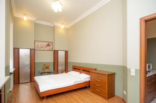 a bedroom with a bed and a wooden dresser at Простора 3 кімнатна біля Майдану Незалежності in Kyiv