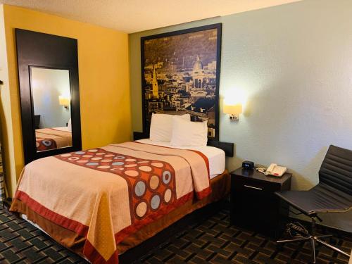 a hotel room with a bed and a chair at Super 8 by Wyndham Cincinnati-Springdale OH in Springdale