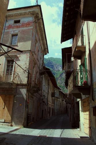an alley with buildings and a mountain in the background at Le Coeur du Pont in Donnas