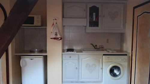une cuisine avec un lave-linge et un lave-linge dans l'établissement Chambres d'Hôtes Le Loubet, à LʼIsle-Jourdain
