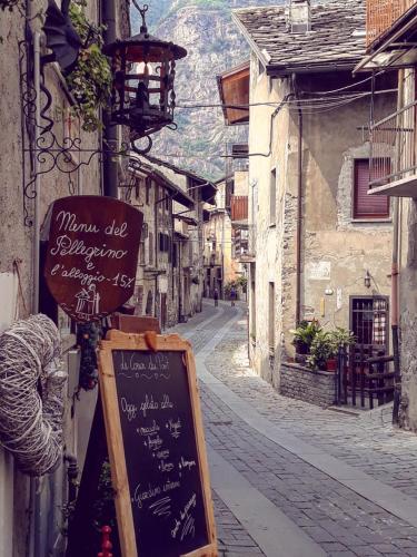 an alley with a sign on the side of a building at Le Coeur du Pont in Donnas