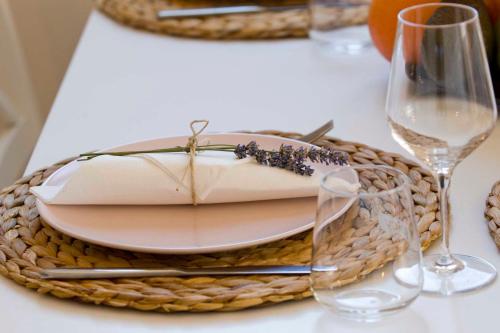 a table with a plate and wine glasses on it at Apartmani Rustica in Drasnice