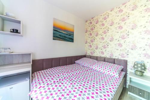 a small bedroom with a bed with flowers on the wall at Pokoje Iga in Władysławowo