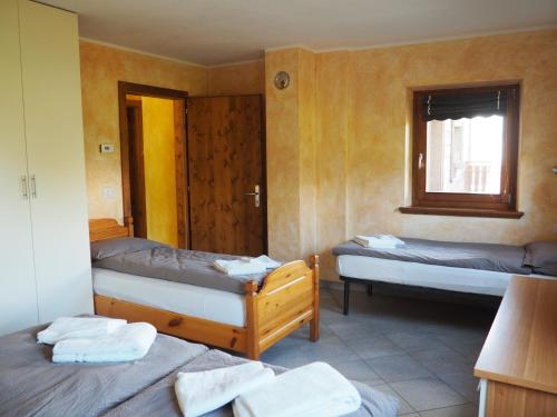 een kamer met 3 bedden en een raam bij Appartamenti Millenium in Livigno