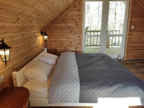 1 dormitorio con 1 cama en una cabaña de madera en Srokowski Dwór 1 - Stara Kuźnia - Prywatna Sauna ! en Srokowo
